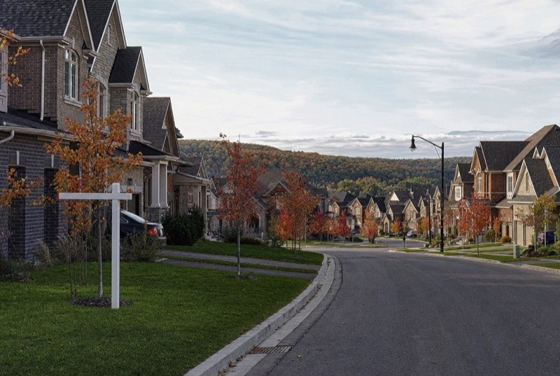 A street of newer brick and stone detached homes in autumn