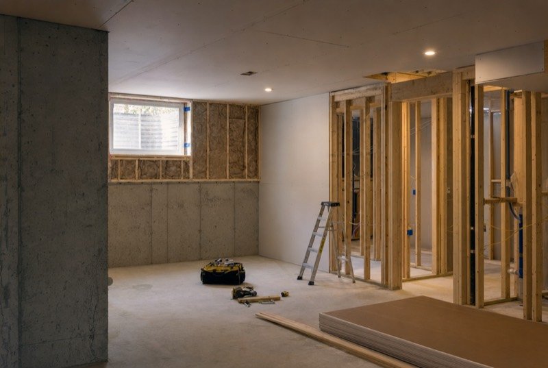 An unfinished new-build basement partway through framing and drywall